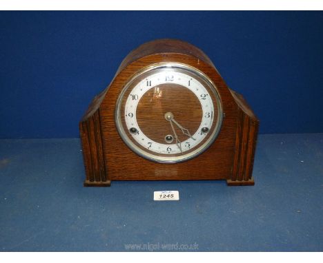 A wooden anvil mantle clock with Arabic numerals and pendulum, no key. 10 3/4" wide x 8 1/2" high x 5" deep.