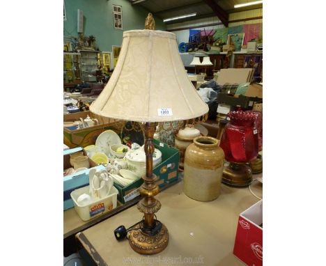 A table lamp with gold effect detail and a cream shade. 33" tall.