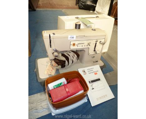 A cased Singer sewing machine complete with toolbox, Singer glue, manual, etc.