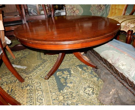 A contemporary circular Mahogany coffee table having cross-banding to the top and standing on a turned pillar with four splay