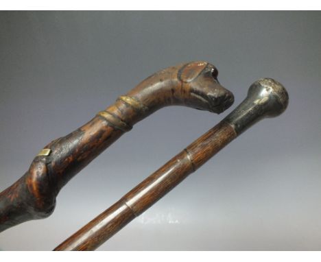 A WOODEN FOLK CARVED WALKING STICK WITH DOG HEAD POMMEL, having inset two-colour glass eyes, the twisted shaft depicting snak