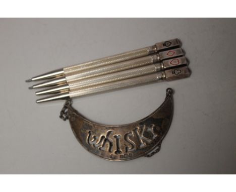 A SET OF FOUR STERLING SILVER BRIDGE PENCILS, together with a hallmarked silver whisky decanter label - Birmingham 1904