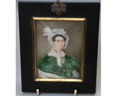 A 19TH CENTURY PORTRAIT MINIATURE STUDY OF A LADY IN A GREEN DRESS AND WEARING A BONNET, unsigned, framed and glazed, 10 x 7 