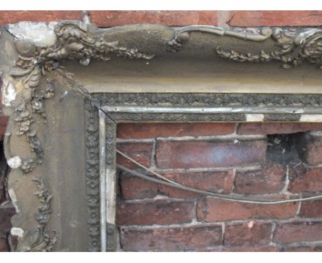 AN EARLY 19TH CENTURY HEAVILY CARVED GILTWOOD PICTURE FRAME, foliate moulding to the frame, bearing inscription 'Thou Art All