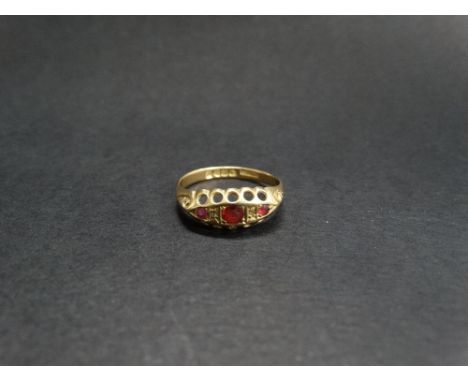 An early 20th century 18ct. gold ruby and diamond chip set ring, the central ruby of 0.10ct. spread approx., Chester 1915, di