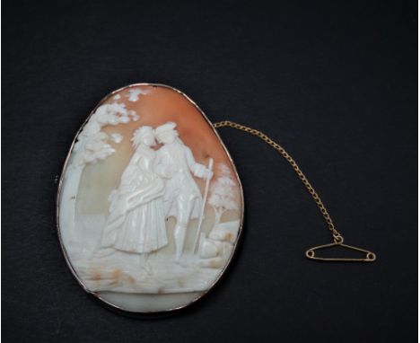 A 9ct. gold mounted oval shell cameo carved with a pair of lovers in a garden, stamped 9ct, 59 x 48mm.