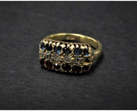 An 18ct. gold diamond ruby and sapphire set seventeen stone ring, the head set with three rows of six sapphires, six rubies a