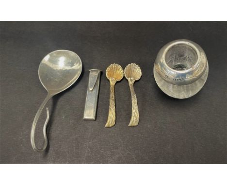 A mixed selection of silver to include a Georg Jensen 925 silver caddy spoon, a small silver topped glass match striker, a mo