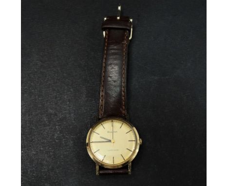 A Bulova Longchamps 9ct. gold cased manual wind wristwatch, the 28mm champagne dial with gilt baton markers, the back of the 