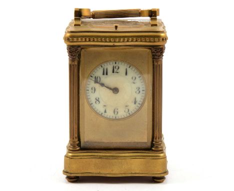 French brass serpentine cased carriage clock, the corners with Corinthian columns, circular dial, repeating movement striking