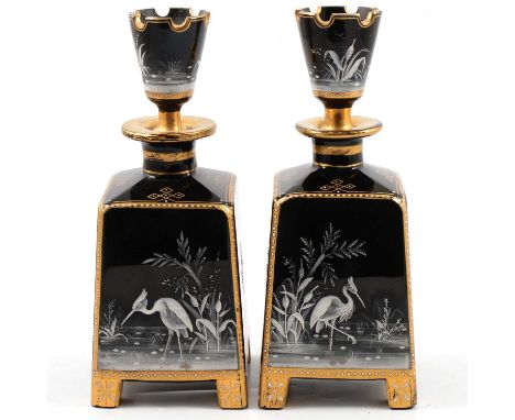 Pair of Victorian black glass and enamelled vases and stoppers, square tapering bodies decorated with herons in white enamel,