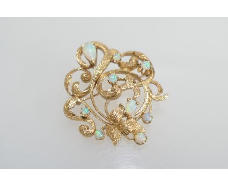 Opal open foliate brooch in 14ct gold, set with nine cabochon opals, the largest of pear shape approx. 7mm, the gold mount wi