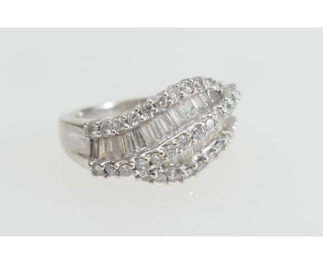 Diamond cluster ring in 18ct white gold, set with tiny brilliants dispersed with two rows of baguette cut diamonds, claw moun