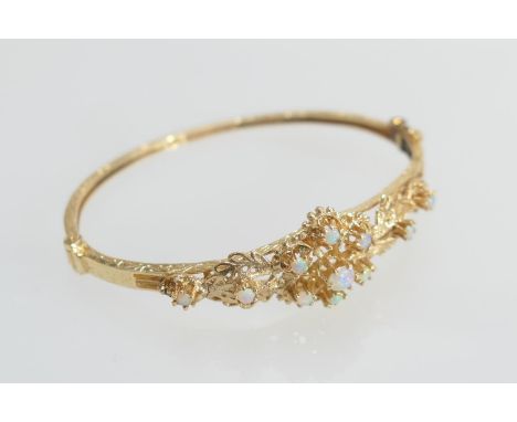 14ct gold opal foliate cluster bangle, set with eleven small cabochon opals, cuff size 62mm, gross weight approx. 15.8g (Plea
