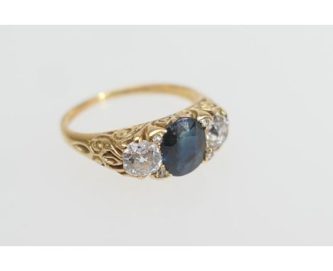 Sapphire and diamond three stone ring, the central oval cut sapphire of approx. 0.75ct flanked by two old European cut diamon