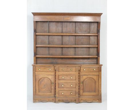 Oak and mahogany breakfront dresser and plate rack, North Wales, early 19th Century, having a three shelf boarded back flanke