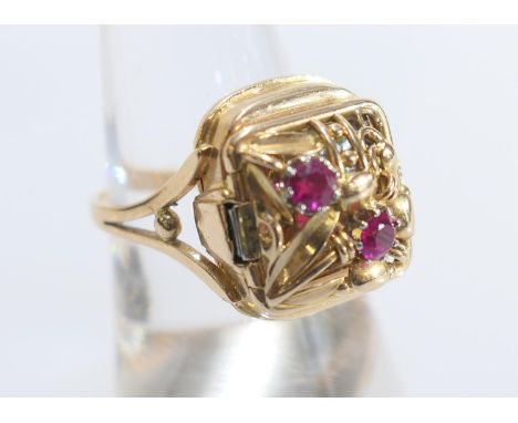 18ct yellow gold watch ring, the hinged cover worked with foliage and set with two round cut rubies, opening to a 10mm gold c
