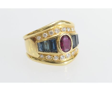 Ruby, sapphire and diamond dress ring, the central oval ruby of approx. 6mm x 5mm, collet set and bordered with six channel s