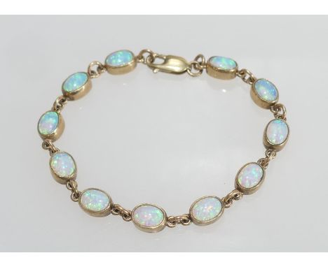 Opal line bracelet in 9ct gold, set with eleven cabochon opals, each of approx. 7mm x 5mm, in collet mounts united by chain l