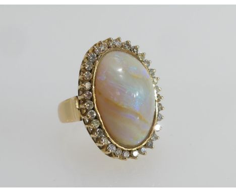 Cabochon opal and diamond dress ring, the central opal of approx. 22mm x 19mm, bordered with a single row of tiny brilliants,