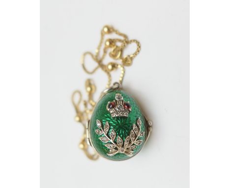 CATALOGUE AMENDMENT: Description now reads An egg form pendant, with green enamelled exterior embellished with red and white 
