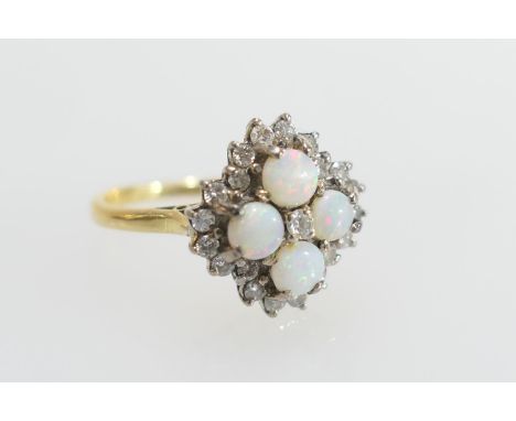Opal and diamond cluster ring, set with four cabochon round opals, centred and bordered with small brilliants, in claw mounts