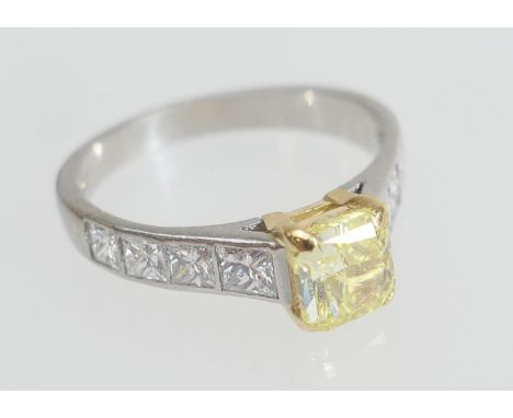 GIA certificated fancy intense yellow diamond ring, the main stone being a rectangular modified brilliant weighing 1.04cts, n