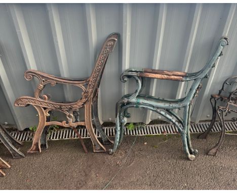 Pair of cast iron bench ends one with wooden arms 