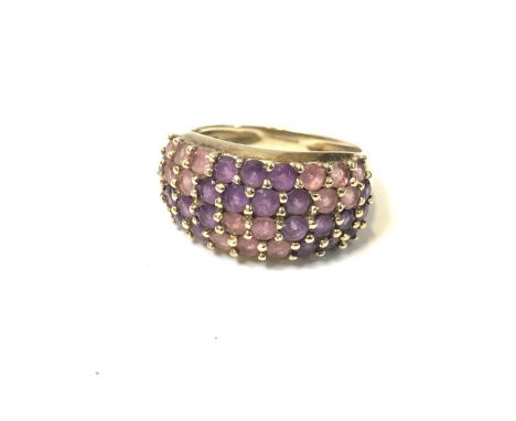 A LADIES 9CT YELLOW GOLD RING WITH PINK AND PURPLE STONES 