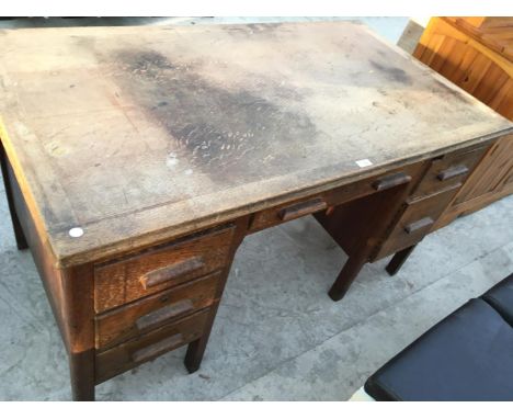 A VINTAGE OAK DESK WITH FIVE SHORT DRAWERS AND ONE LONG DRAWER 