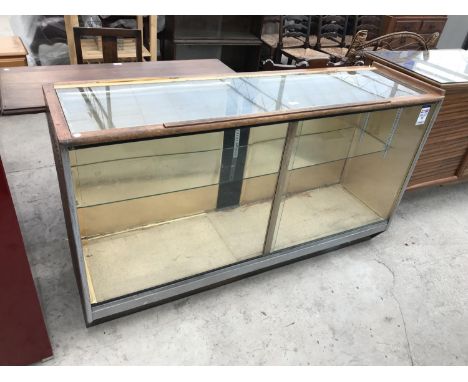 AN OAK FRAMED GLASS SHOP DISPLAY CABINET WITH MEASURING STICK AND INTERIOR GLASS SHELF 