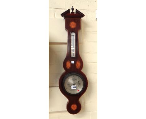 An Edwardian wheel barometer by Ross London, the broken arch pediment over a mahogany and inlaid case, with applied thermomet
