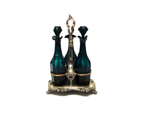 A Sheffield plated three bottle decanter stand, the triform base decorated with a scrolling border, with a loop shaped handle