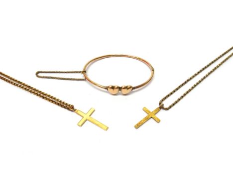A gold oval hinged bangle, with twin heart shaped motifs, a gold pendant cross, with scroll engraved decoration, with a gold 