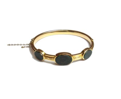 A Victorian gold and bloodstone set oval hinged bangle, the front mounted with three oval bloodstones, otherwise having a dec