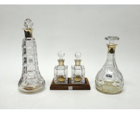 Two silver mounted faceted glass decanters, including one London 1921 and a pair of silver mounted small moulded square glass