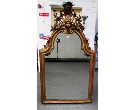 A Victorian gilt framed arch top wall mirror, the pierced crest relief carved with a blackamoor, over shaped bevelled mirror 