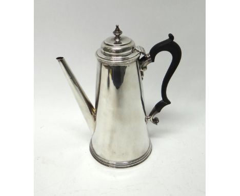 A silver teapot of tapering cylindrical form, on a reeded circular foot, fitted with a black handle, in the 18th century tast