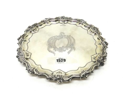 A silver salver, of shaped circular form, engraved to the centre with a foliate cartouche, within a piecrust rim, decorated w