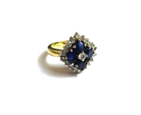 A gold, sapphire and diamond set cluster ring, mounted with the principal circular cut diamond at the centre, in a surround o