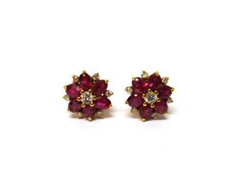 A pair of gold, diamond and ruby set cluster earstuds, each claw set with the principal circular cut diamond at the centre, w