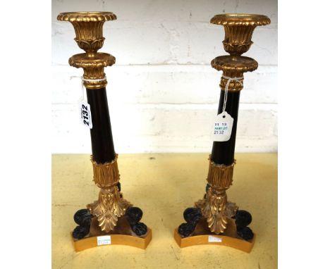 A pair of gilt and patinated ormolu candlesticks of Georgian style, 20th century, each acanthus cast sconce atop a circular t