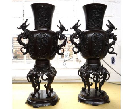 A pair of modern bronze Chinese vases on stands, each with dragon handles and foliate cast decoration, 36cm high (2).