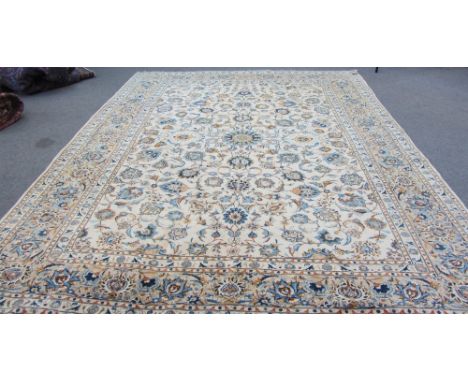 A Kashan carpet, Persian, the beige floral vine field with a central faceted medallion, a darker beige complementary border, 