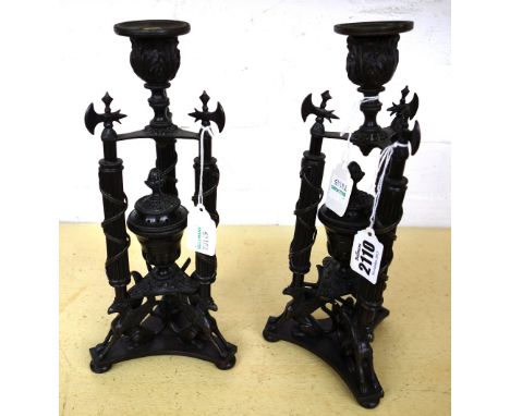 A pair of George IV style bronze candlesticks, the fluted uprights with axe head finials and foliate nozzle on three griffin 