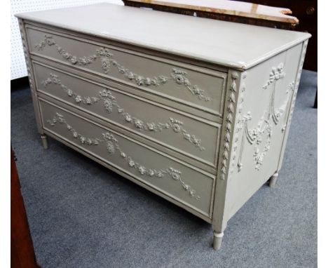 An 18th century style painted Continental three drawer commode with moulded floral swag decoration, 133cm wide. 