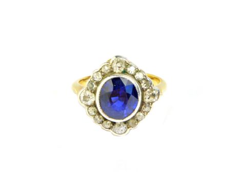 A gold, sapphire and diamond set shaped oval cluster ring, collet set with the oval cut sapphire at the centre, within a surr