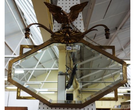 An Art Deco wall mirror with eagle surmount and twin light fitting over bevelled shaped mirror plate, 77cm wide x 70cm high.