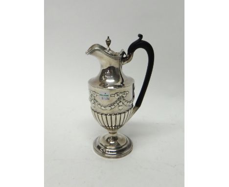 A late Victorian silver hot water jug, of ewer form, with partly fluted and swag embossed decoration, on a circular foot, the