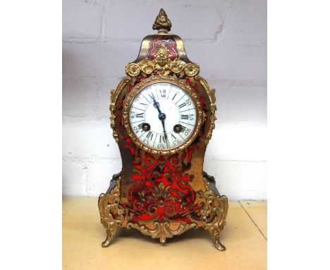 A boulle work mantel clock, late 19th century, with foliate brass finial over a shaped case, with enamel dial and two train m